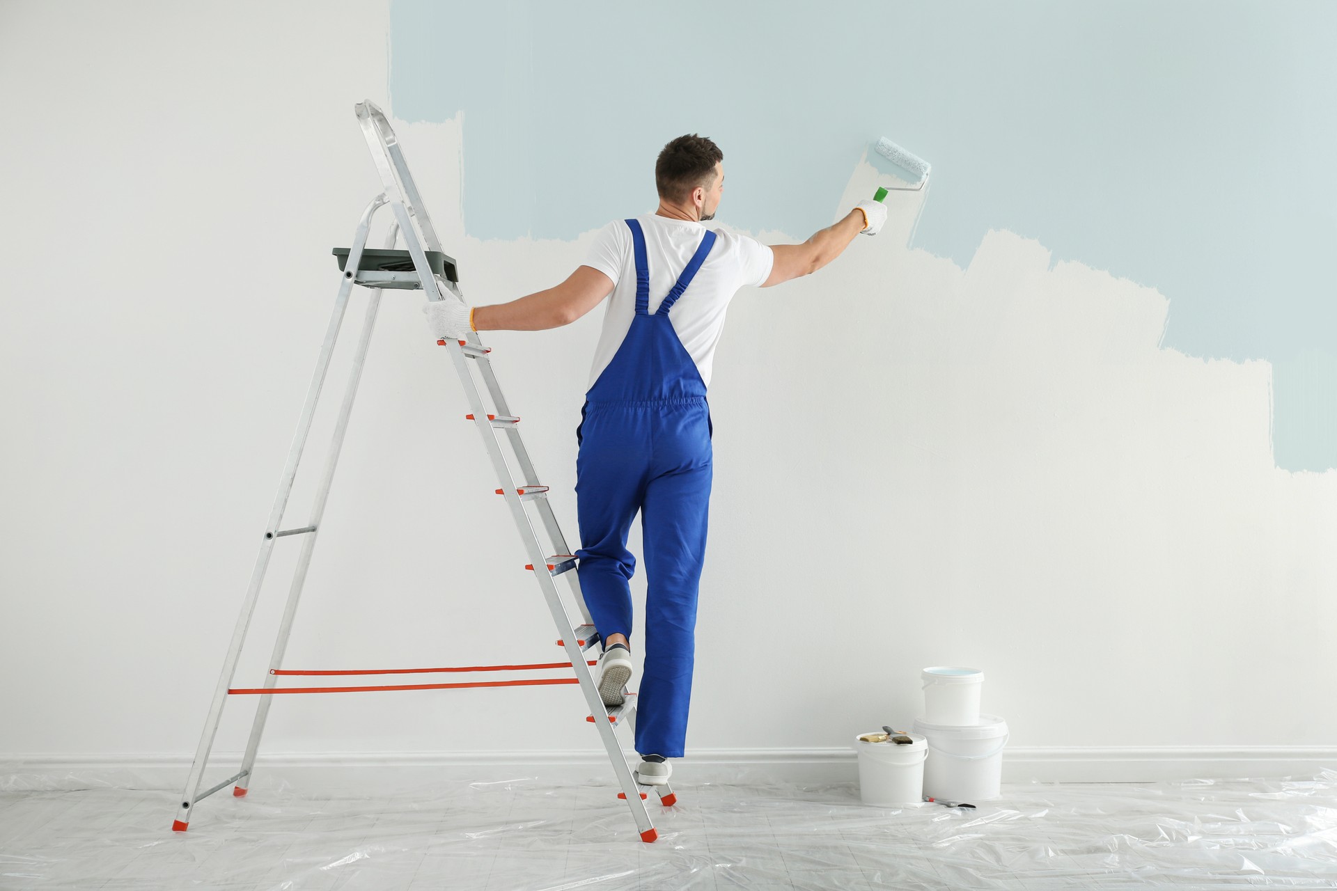 Mur de peinture de l’homme avec colorant bleu clair à l’intérieur, vue arrière